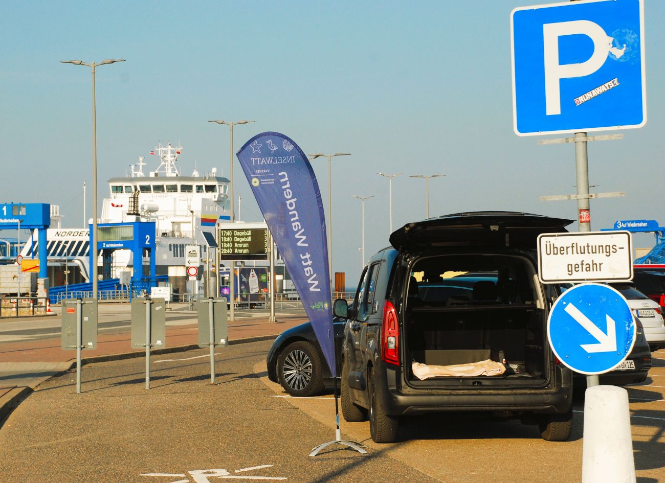 Wyk Hafen - Parkplatz unterhalb des WDR Gebäudes - Schwarzes Auto + blaue Flagge